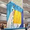 Indoor Rock Climbing Wall With Vibrant Blue Yellow Sections And Climbing Holds In Shopping Mall