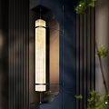 Long Cylinder Wall Lamp With Glass Shade On Dark Vertical Striped Wall And Green Plants