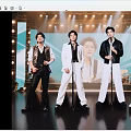 Men Performing Singing On Stage With Microphones And Bright Stage Lights