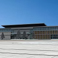 Modern Public Building Facade With Large Glass Windows Gray Walls And Plaza