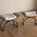 Two Modern Black Metal Frame Stools With White Rolled Towels On Wooden Floor