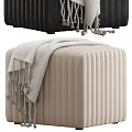Black and Beige Vertical Pleated Ottomans Featuring Gray Blanket and Tassel Accents