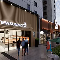 Lively Modern Commercial Street with Shops Pedestrians Trees and High rise Buildings