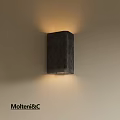 Dark Colored Square Wall Lamp With Textured Surface Mounted On Wall Illuminating Warm Light