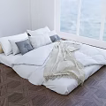Double Floor Bed With White Comforter Pillows Beige Throw And Geometric Floor