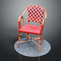 Red Wicker Chair With Patterned Backrest Curved Armrests And Metal Frame On Round Gray Mat