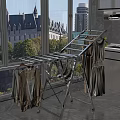 Silver Metal Clothes Drying Rack Foldable Design Near Window With Dresses And Cardigans