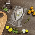 Fresh Vacuum Sealed Fish with Lemon Slices Rosemary Tomatoes Salt Pepper on Wooden Cutting Board
