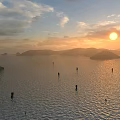 Stunning Sunset Lake Landscape With Distant Misty Mountains And Golden Sunlight Shining On Calm Water