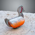 Wooden Building Blocks Duck Shaped Rocker With Orange Seat Placed On Sand Surface