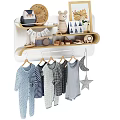 Baby Clothes Hanging On Rack By Wooden Shelf With Decor