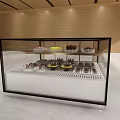 Glass Display Cabinet Shelf with Multiple Layers Showcasing Colorful Desserts for Bakery Shop