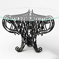 Round Glass Top Dining Table With Intricate Black Metal Wrought Iron Base And Curved Details