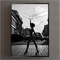 Black and White Figure Painting Featuring Female Holding Large Petal Shaped Sculpture in Urban Street Setting