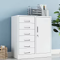 White Bookcase With Drawers And Doors Alongside Woven Baskets Green Plant Light Blue Wall