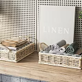 Set of Woven Storage Baskets with Folded Linens and Rolled Towels on Wooden Countertop