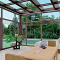 Sunroom With Brown Frame Large Glass Panels Front Lawn Stone Pathway And Outdoor Stools