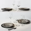 Modern Dinnerware Set with Dark Plates White Spots Wine Glasses and Tumblers on White Table