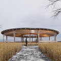 Scenic Circular Open Air Pavilion With Person Walking On Path In Wheat Field