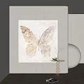 Light Toned Butterfly Painting Hanging On Wall With Light Wall Background And Small Table Plant