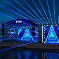Vibrant Music Festival Stage With Blue Laser Beams Triangular Screens And Lighting Effects