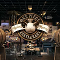 One Piece Themed Bar Interior With Wooden Barrels Chandeliers And Glass Topped Tables