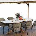 Oval Outdoor Table with Wicker Chairs and Beige Umbrella on Wooden Patio with Flower Vase