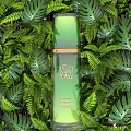 Natural Botanical Green Perfume Cosmetic Bottle With Golden Accents And Lush Plant Background