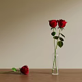 Red Roses In Transparent Glass Vase With Fallen Rose On Wooden Table