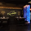 Stylish Bar Interior With Bar Counter Wine Racks Dining Tables And TV Screen