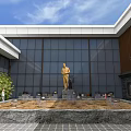 Industrial Interior Space Featuring Circular Stone Wall With Golden Statue And Green Plants