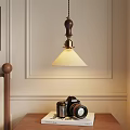 Vintage Pendant Light Hanging Over Retro Camera On Bedside Table With Wall Decor