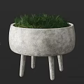 Concrete Planter With Three Legs Filled With Lush Green Grass As Decorative Garden Ornament
