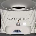 Modern Office Reception Area With Receptionist At White Desk Circular Ceiling Light And Potted Plant