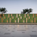 Scenic Feature Wall With Green And Orange Geometric Patterns Against Trees And Gray Stone Pavement