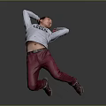 Man Kneeling Arms Raised Behind Head In Grey Green Print Top Red Pants Grey Background
