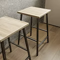 Light Wood Top Bar Stools With Black Metal Legs Against Gray Wall And Wooden Floor
