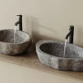 Stone Oval Washbasins On Wooden Countertop With Black Faucets And Light Colored Wall