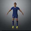 Man in Blue Soccer Jersey and Blue Shorts Standing on Gray Background with Yellow Shoes