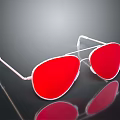 Stylish Sunglasses With Red Lenses And White Frame On Reflective Surface