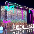 Vibrant Pool Party Photo Spot With Neon Lights Glitter Wall And Hanging Decorations