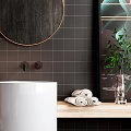 Washbasin with White Pedestal Wooden Countertop Black Tiled Wall Round Gold Frame Mirror and Towels