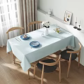 Bright Sunlit Minimalist Dining Room With Natural Wood Chairs And Soft Light Blue Tablecloth
