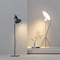 Modern Black and Gold Floor Lamp with White Shade Small Plant Near Light Wall