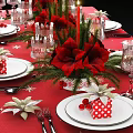 Christmas Dinnerware Set with Red Tablecloth Snowflake Patterns Plates Forks Glassware and Floral Decorations