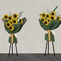 Floral Display With Sunflowers Green Wrapping And Orange White Ribbons On Black Tripods
