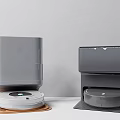 Smart Robot Vacuums With Gray And Dark Gray Charging Docks On Mats