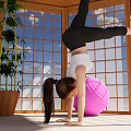 Woman Doing Handstand On Pink Exercise Ball In Room With Large Windows And Green Plant