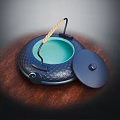 Dark Crocodile Pattern Pot With Green Interior Wooden Handle And Lid On Wooden Tabletop
