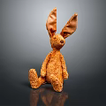 Brown Fluffy Stuffed Rabbit Toy With Long Ears Sitting On Dark Background